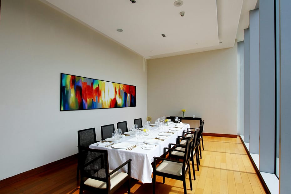 Bright dining room with modern art, set for a formal event. Minimalist and sophisticated design.